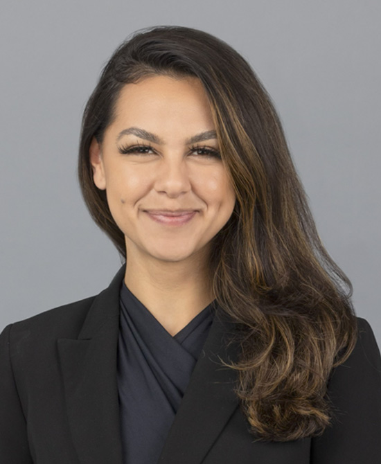 Woman with dark hair and a black suit